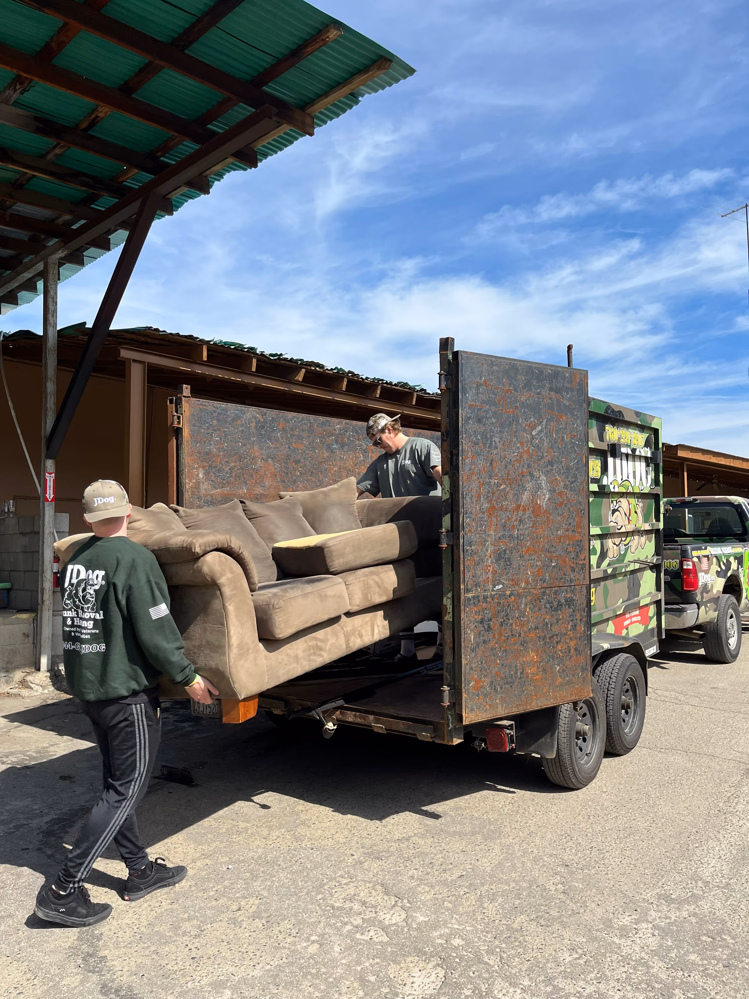 The JDog guys loading an old couch into the back of the JDog trailer.