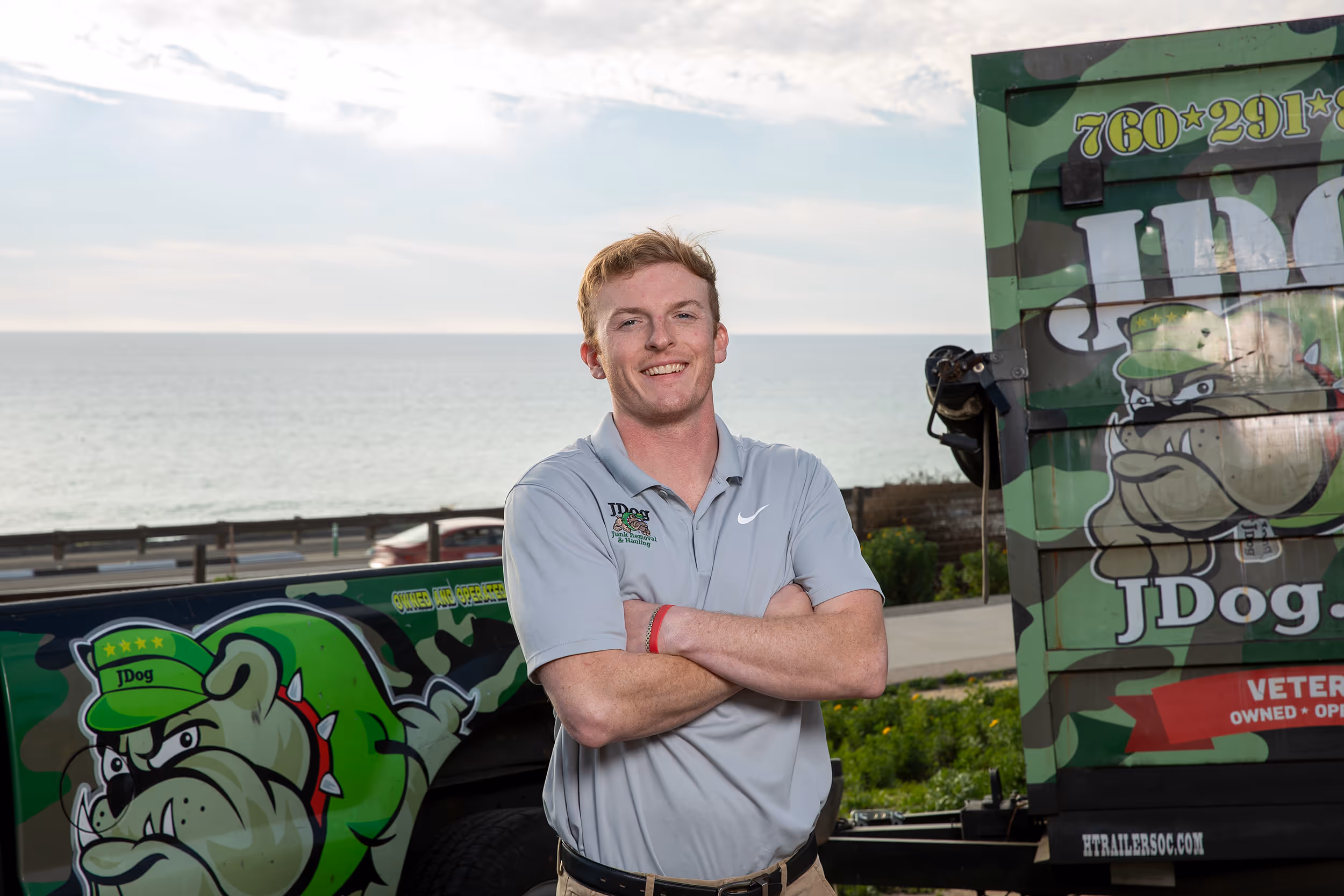 Seamus Fitzpatrick smiling in front of a JDog vehicle.