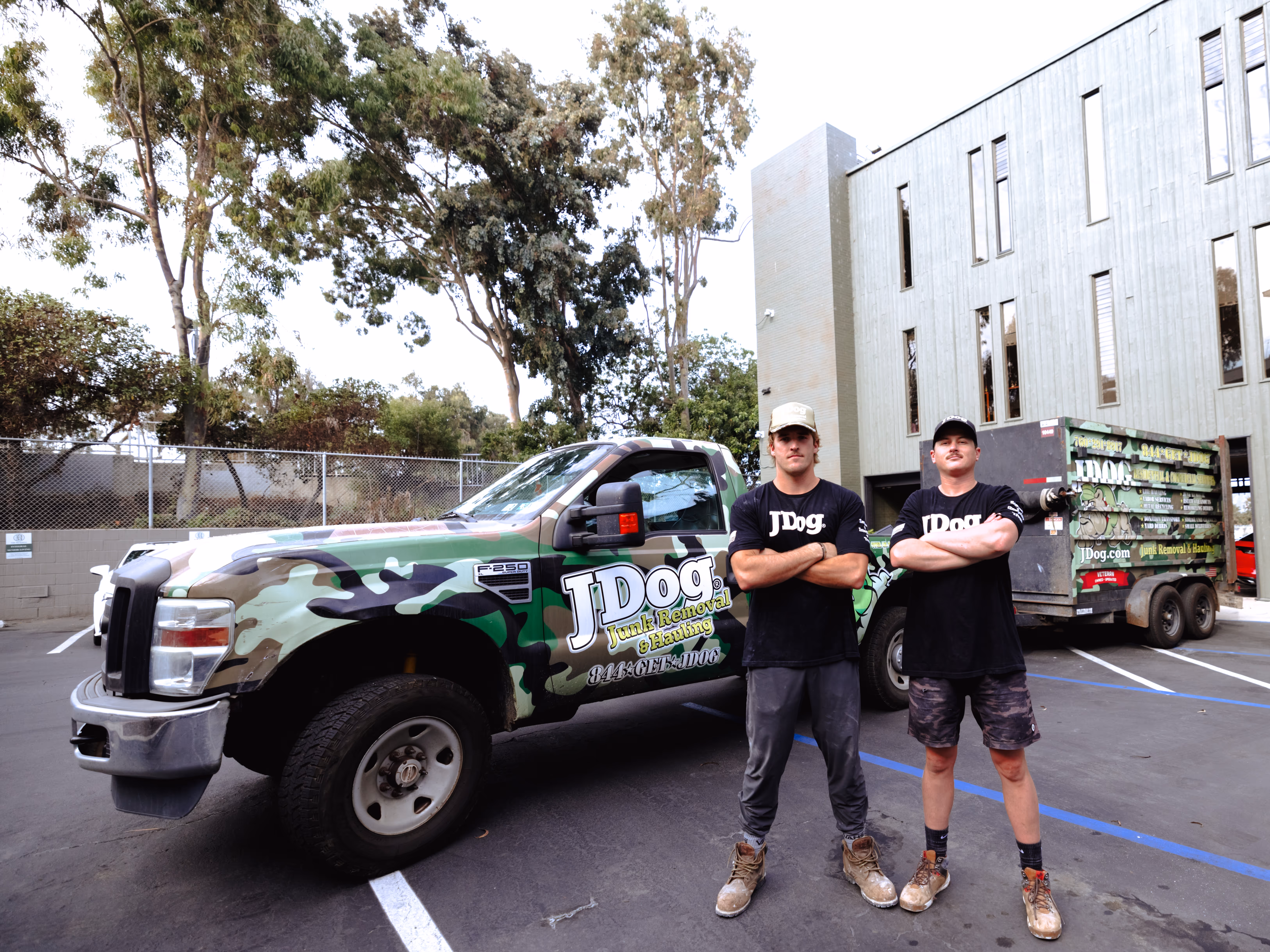 Ryan and Scott standing with arms crossed in front of the JDog truck and trailer.