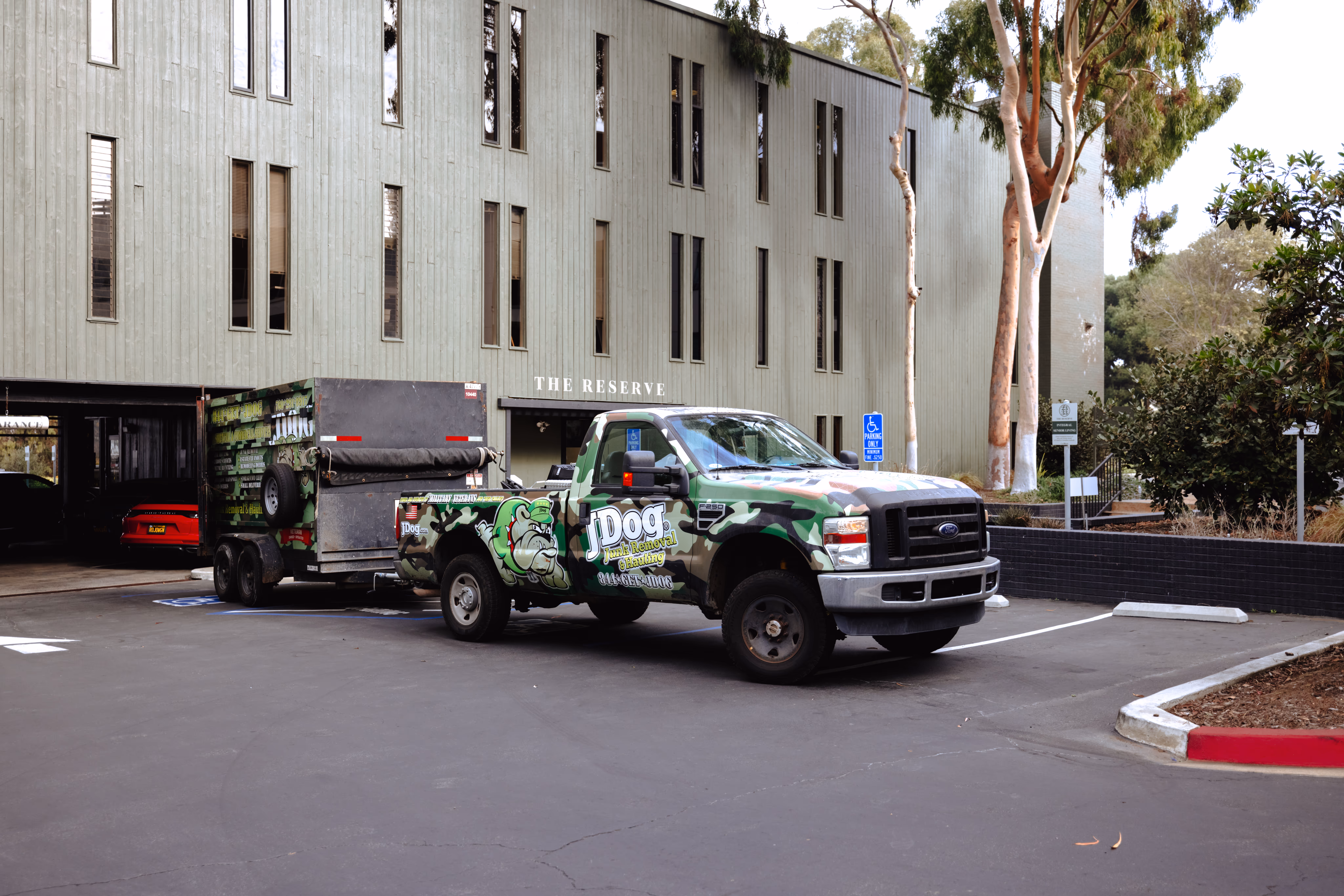 The JDog truck and trailer parked in front of a local business.